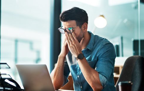 Antreprenor analizând situația financiară dificilă a companiei la laptop în birou