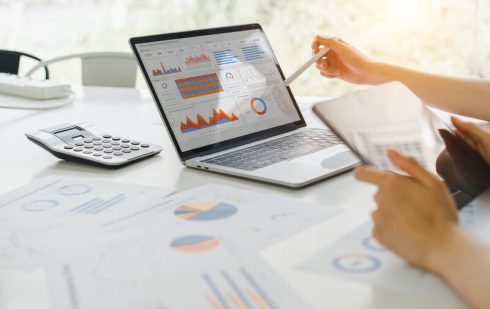 Specialist analizând date financiare și grafice pe laptop în vederea optimizării fiscale a companiei