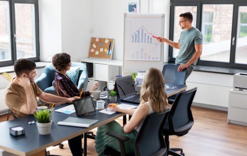 Prezentare de date economice în scădere într-o ședință de echipă, ilustrând impactul recesiunii asupra afacerilor